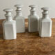 4 old white pharmacy style bottles