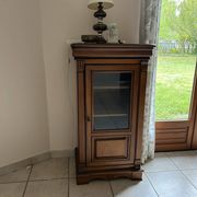 Small glass-fronted accent cabinet in cherry wood.