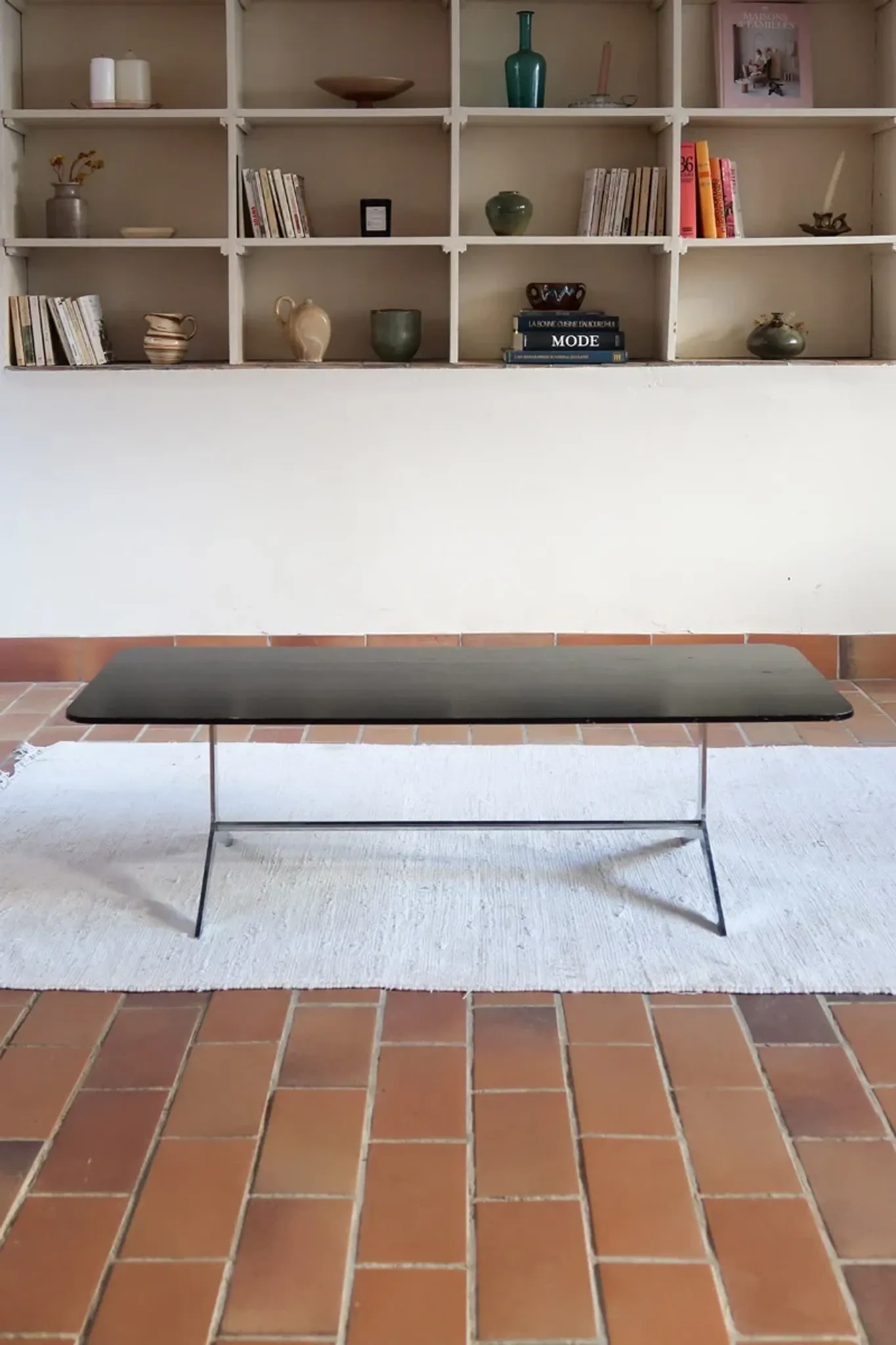 70s design coffee table with a black top and steel legs.