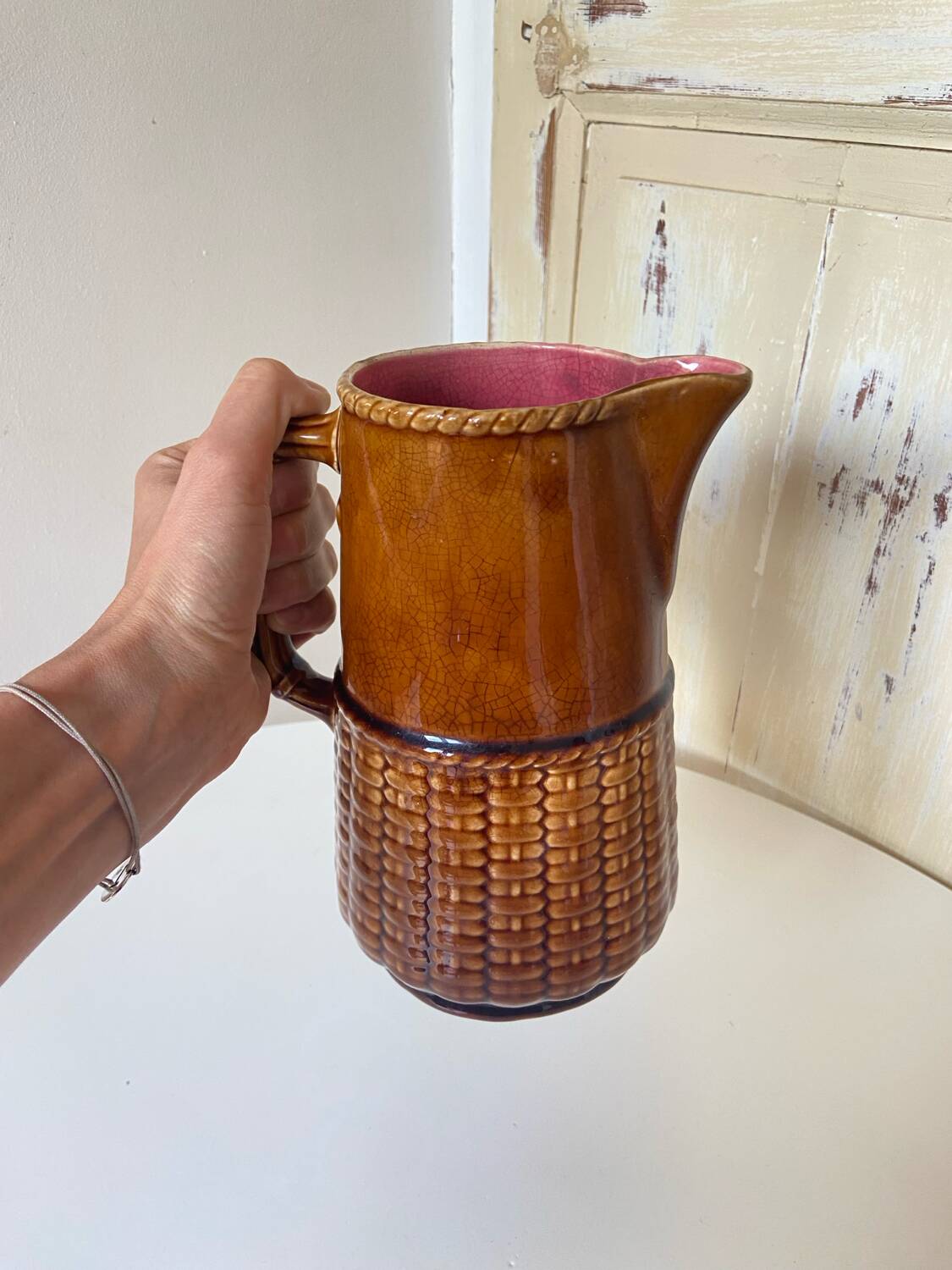 Antique vintage ceramic pitcher or jug from Sarreguemines, France. Brown with a pink interior, imitation basket.