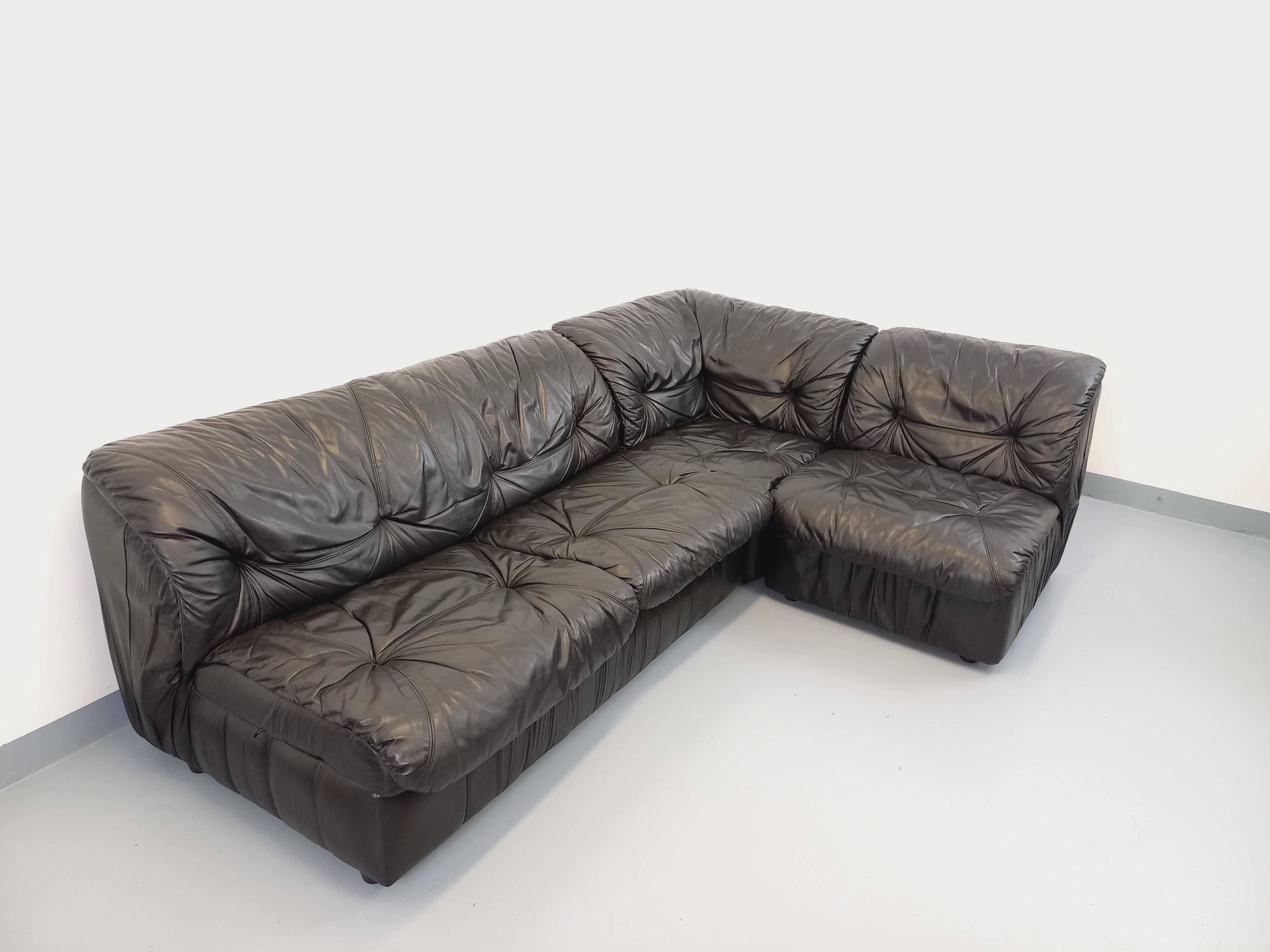 Vintage corner sofa composed of 3 modules in black leather with integrated bed.