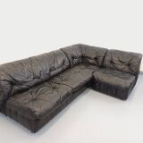 Vintage corner sofa composed of 3 modules in black leather with integrated bed.