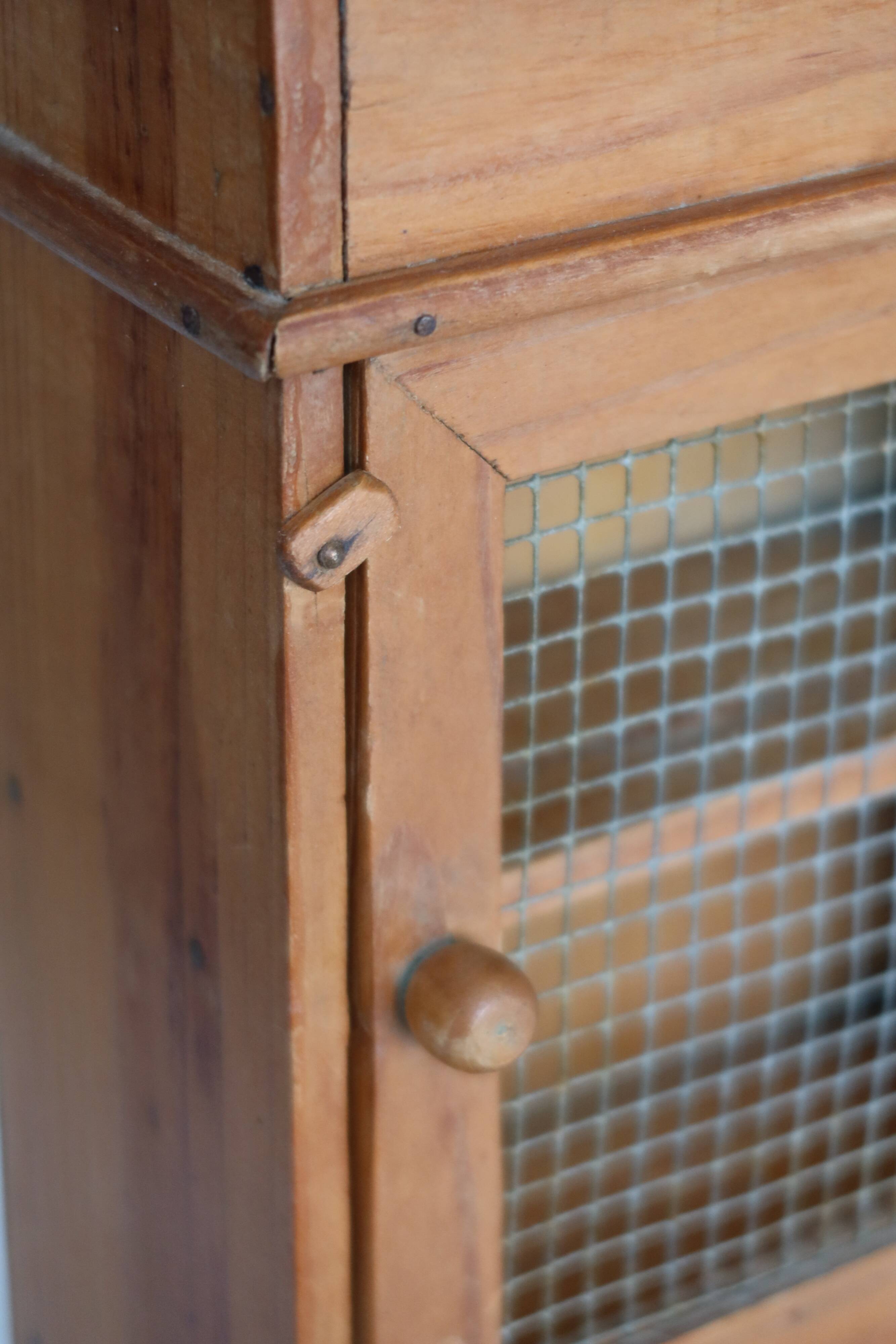 Vintage wooden shelf with drawers and mesh door.