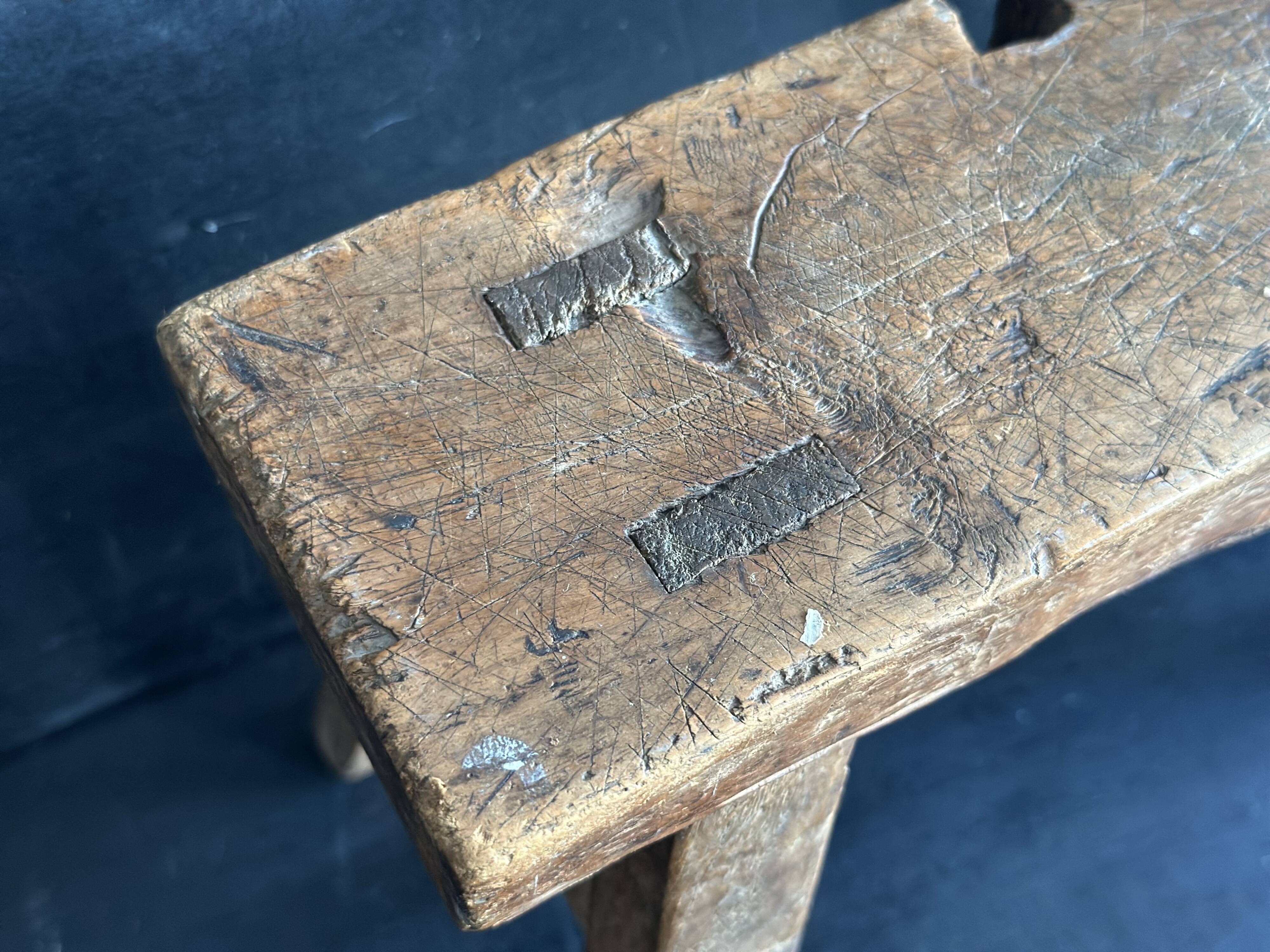 Ancient Chinese farm bench in patinated wood, small rustic stool.