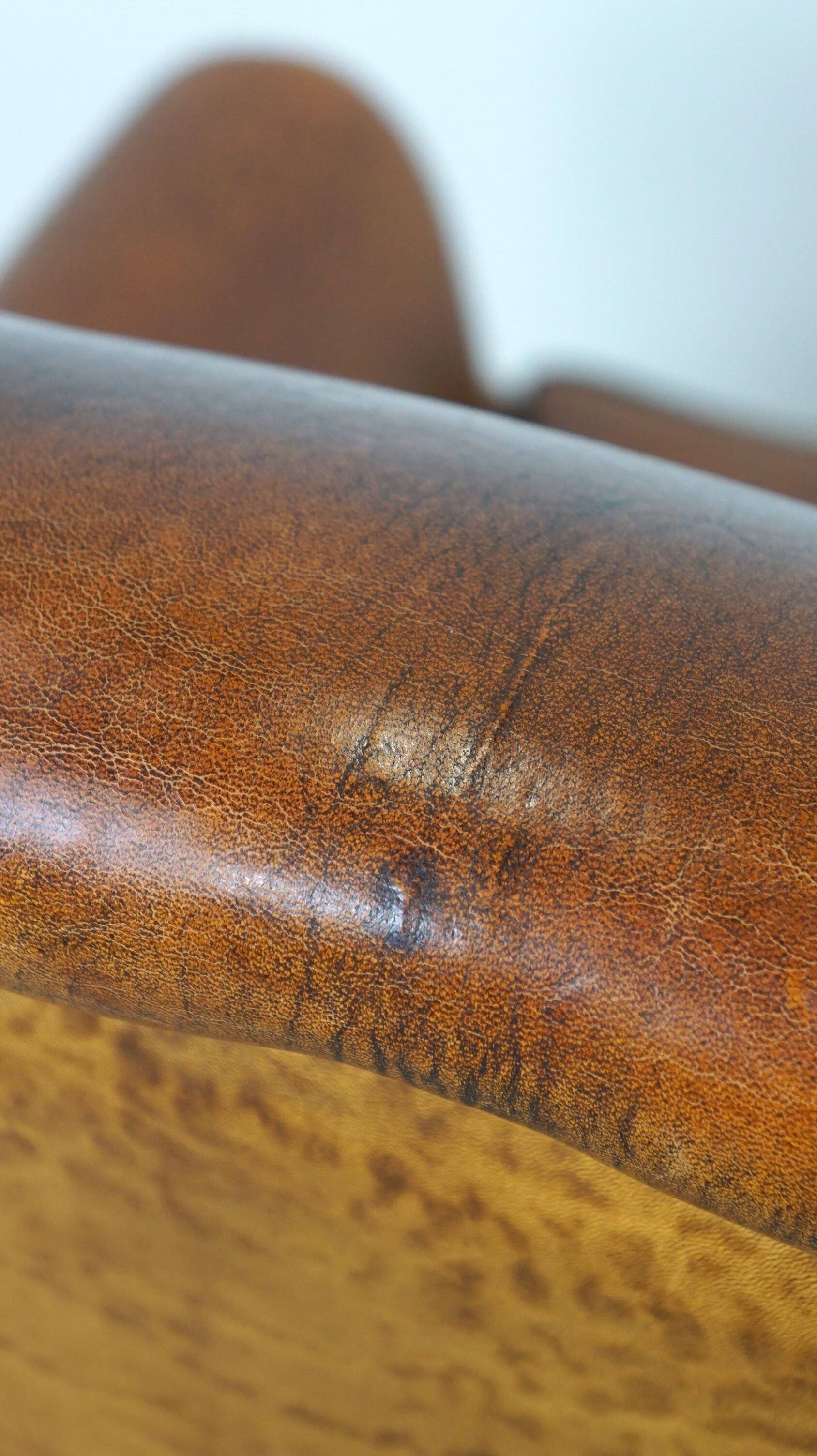 Sheepskin leather wingback armchair, with nails and black piping