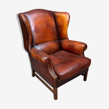 Vintage wing chair made of dark brown sheep leather