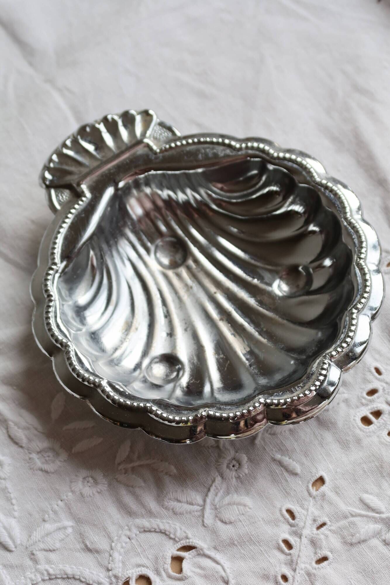 Vintage shell-shaped shiny silver-plated catchall.