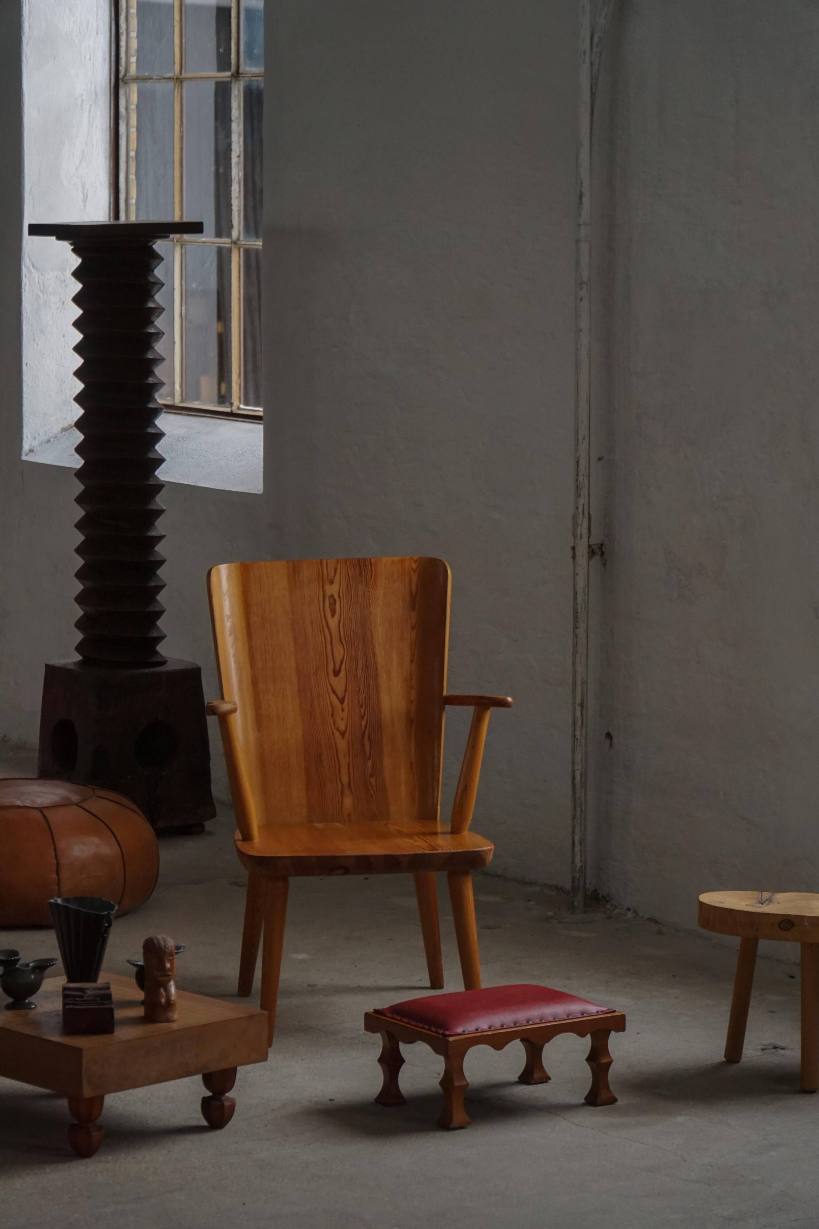 Danish sculpted oak stool from the mid-20th century with a red leather seat, 1950s.