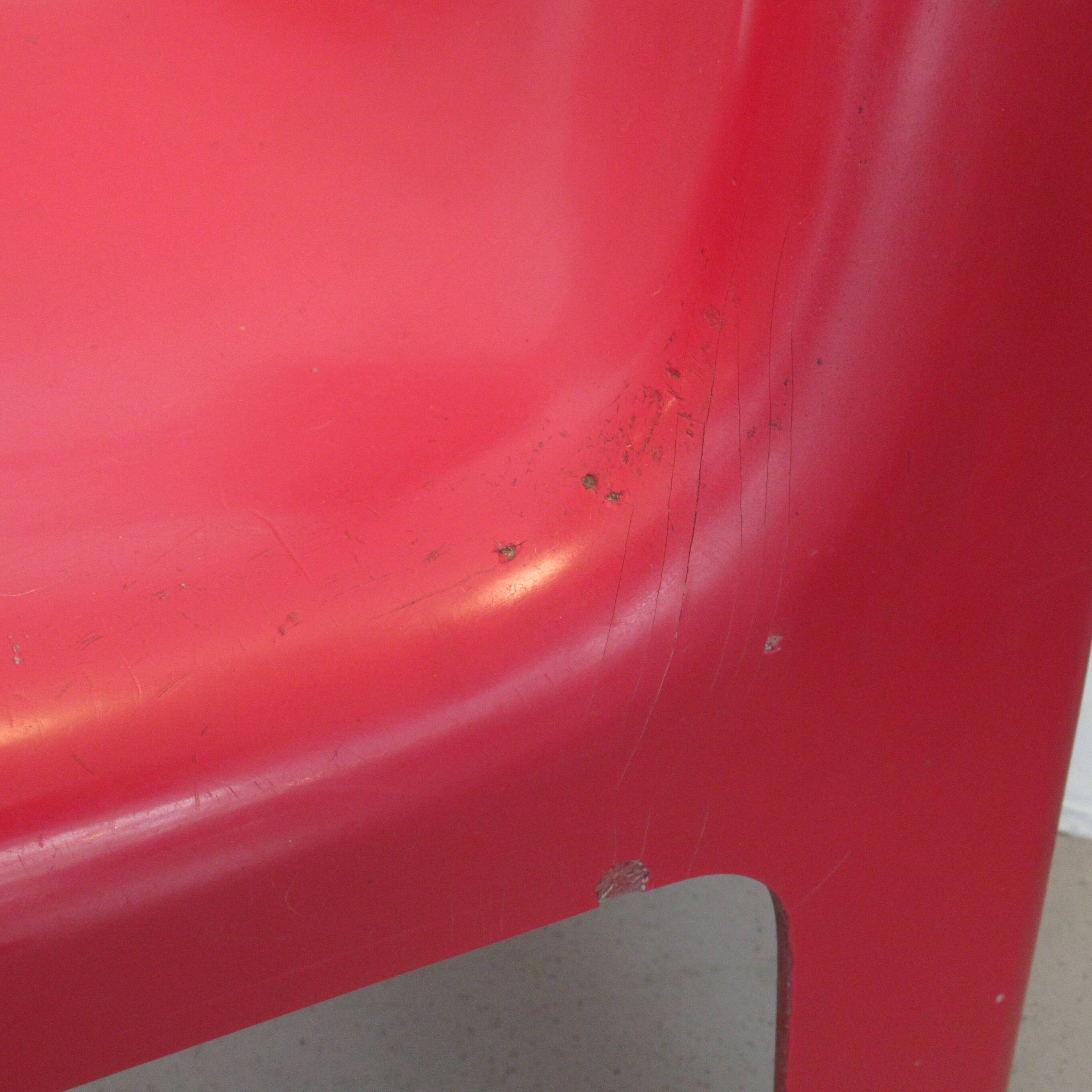 Four red fibreglass chairs from the 1970s.