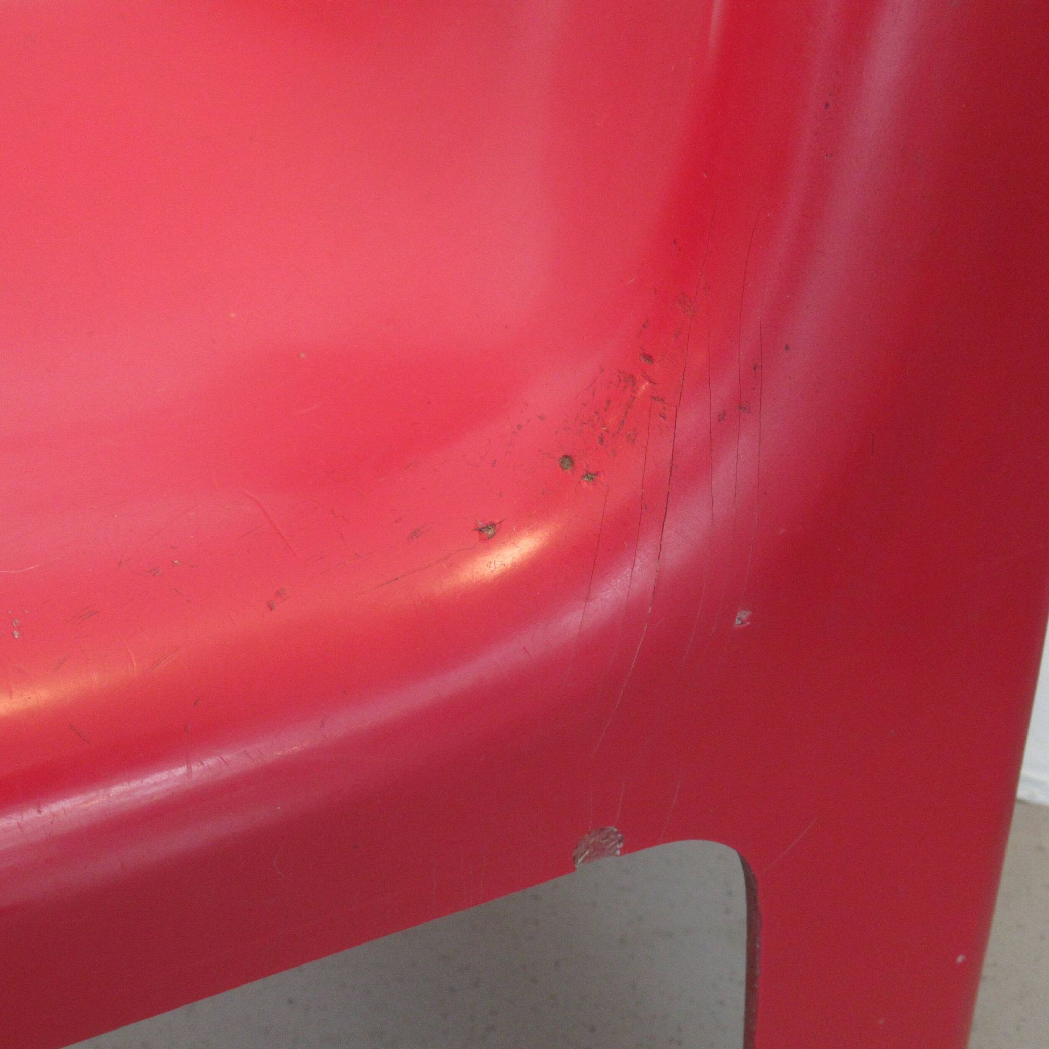 Four red fibreglass chairs from the 1970s.