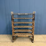 Old wooden workshop shelf with cast iron wheels.