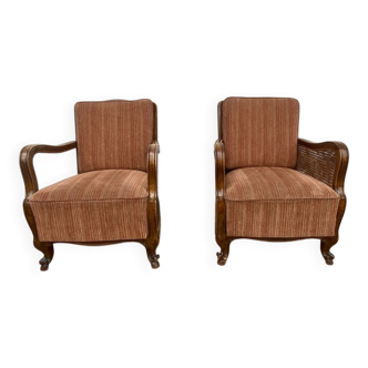 Pair of 1920s brown armchairs in carved wood and fabric, with caning detail.