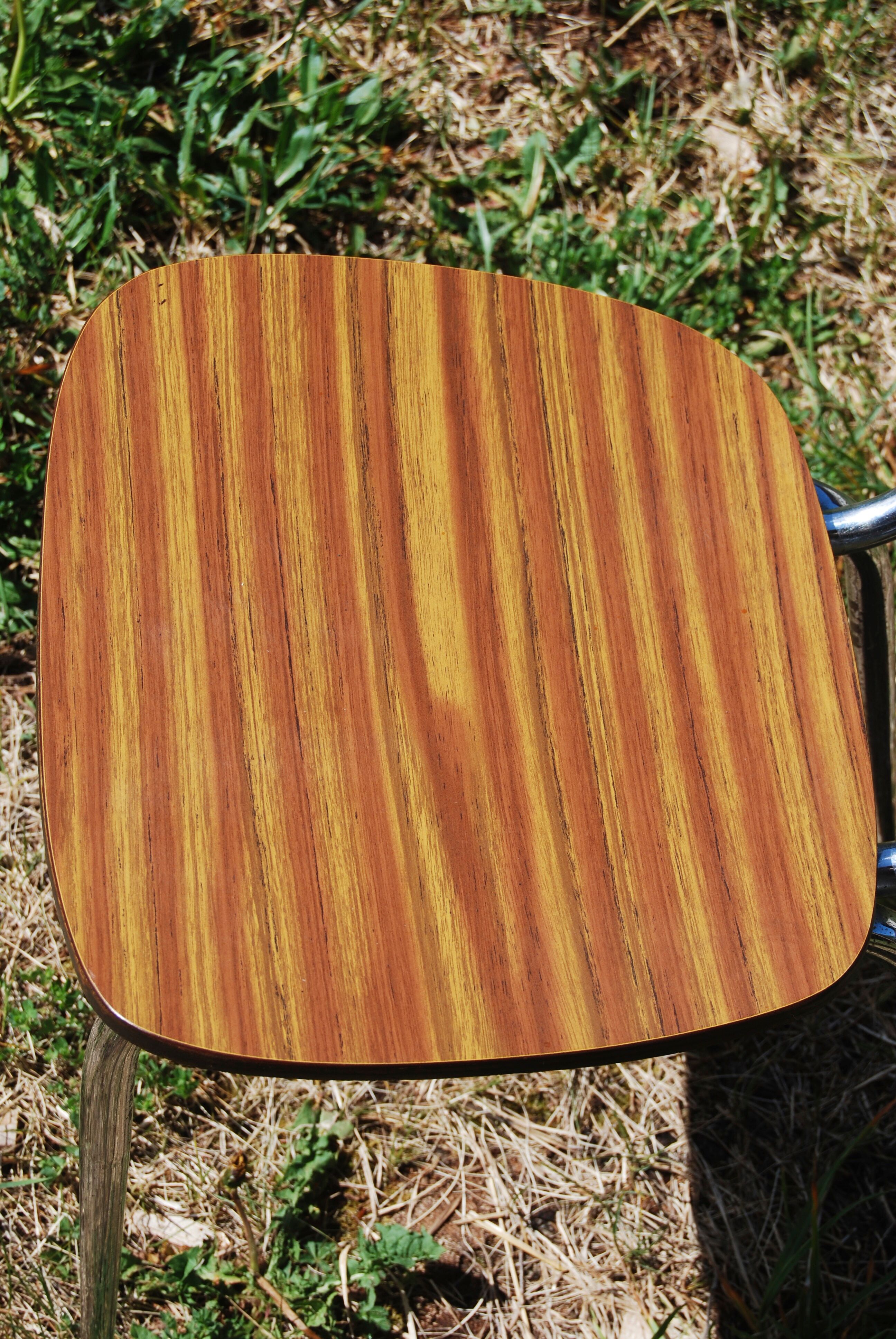 Pair of formica chairs with chrome metal backs in the shape of a lyre.