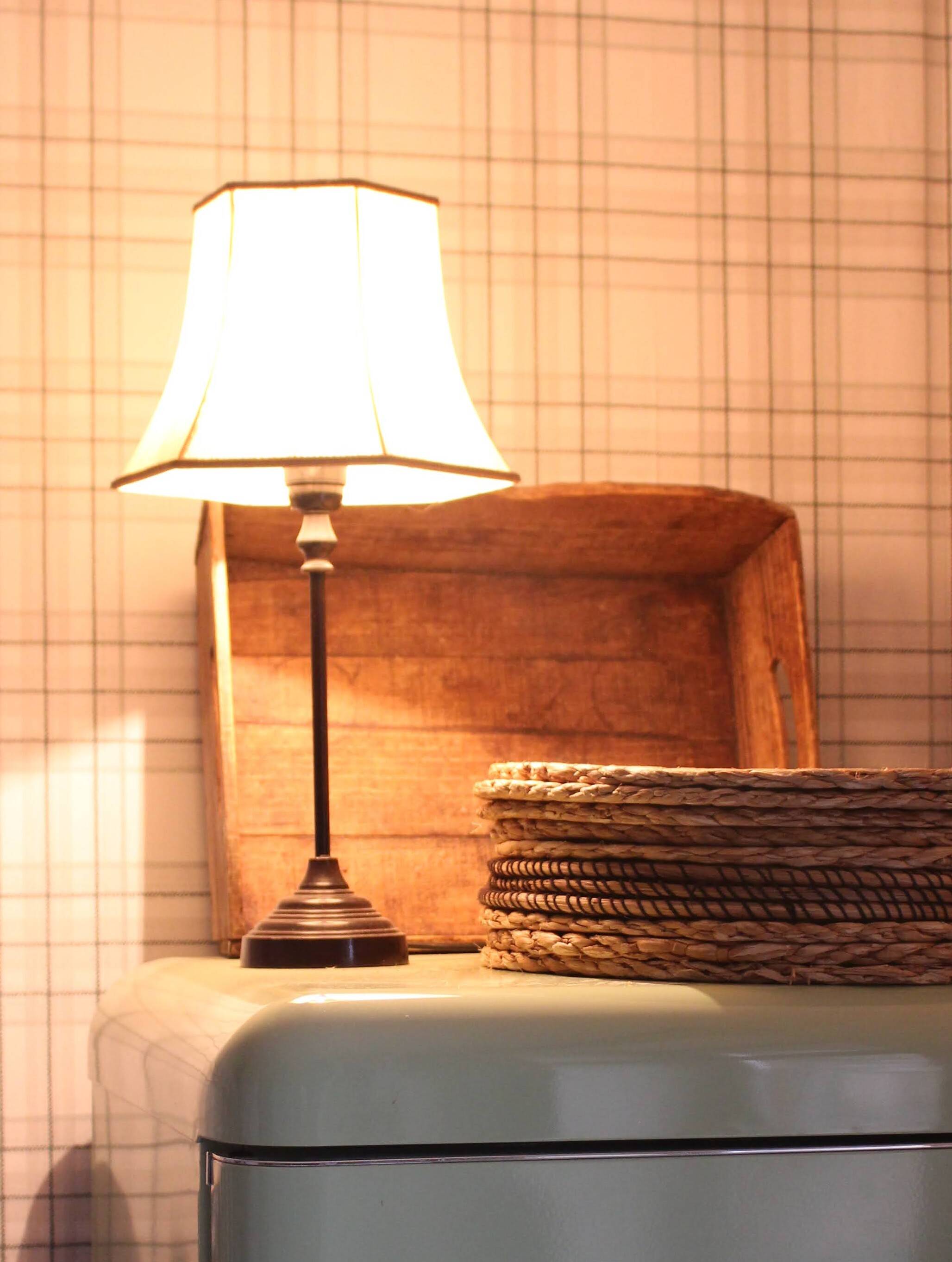 Table lamp with a patinated base and vintage woven shade.