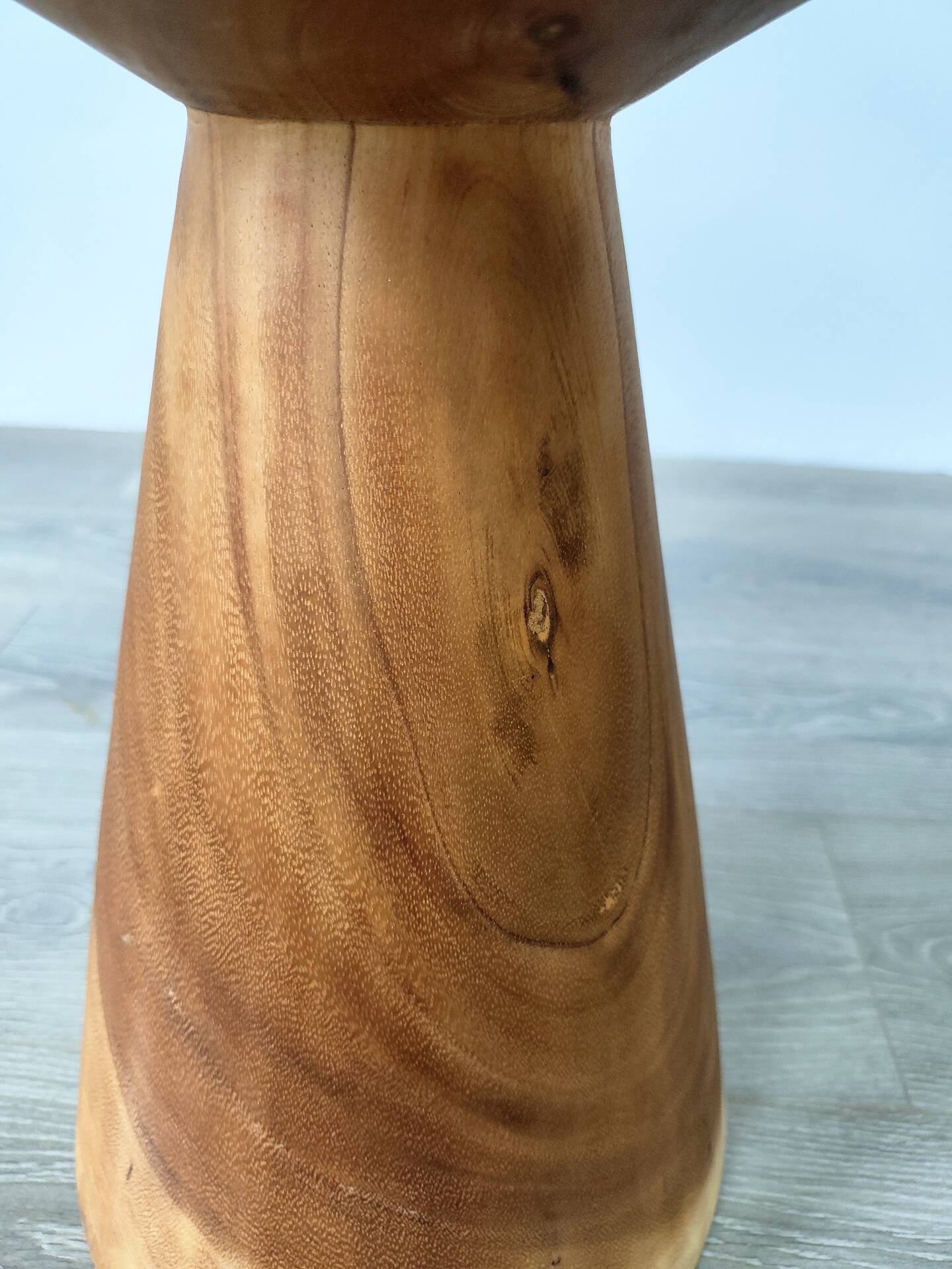 Minimalist side table in solid suar wood with conical legs.