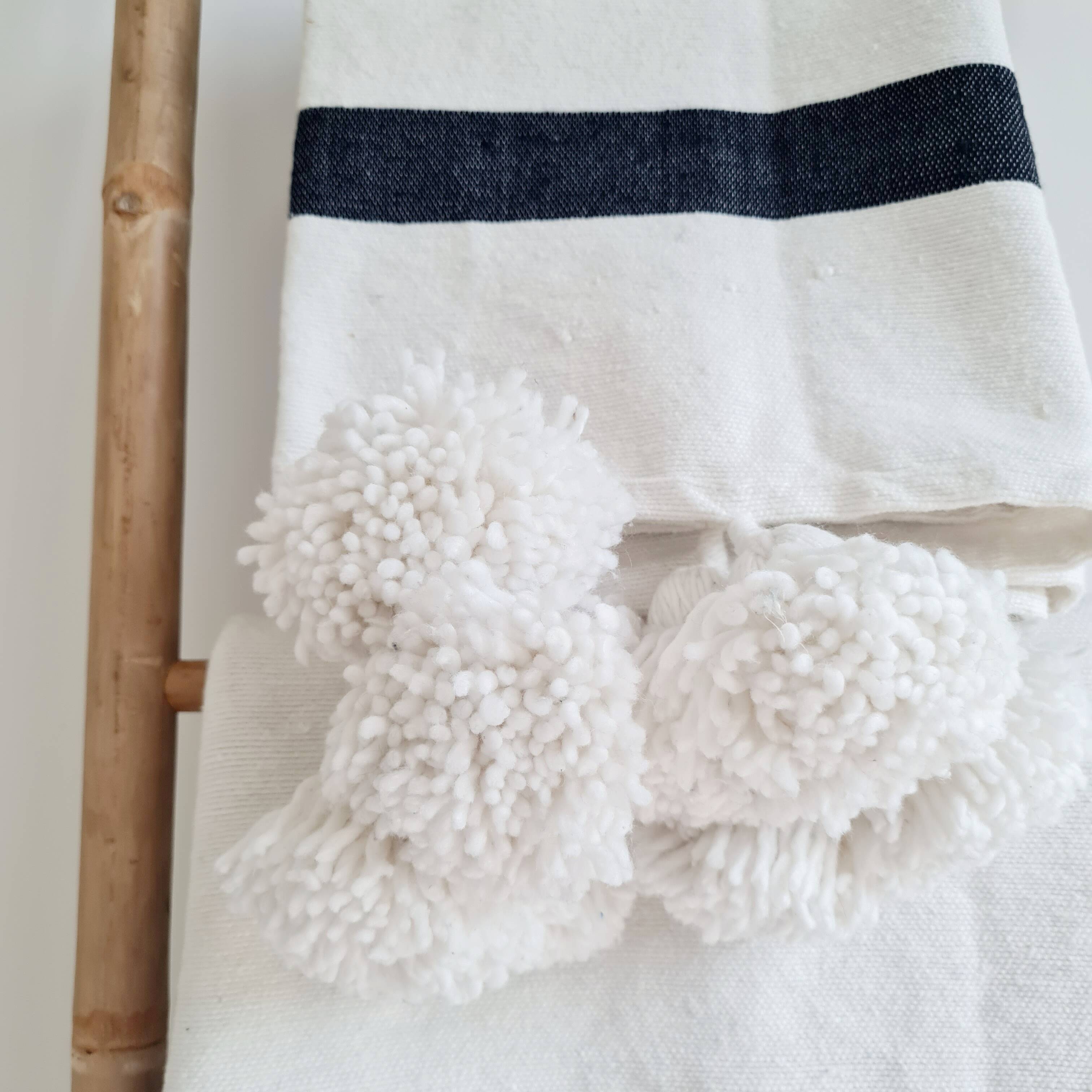 Plaid tissé main rayures noires pompons blancs