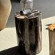 Black petrified wood side table with beige stripes and a semicircular shape.