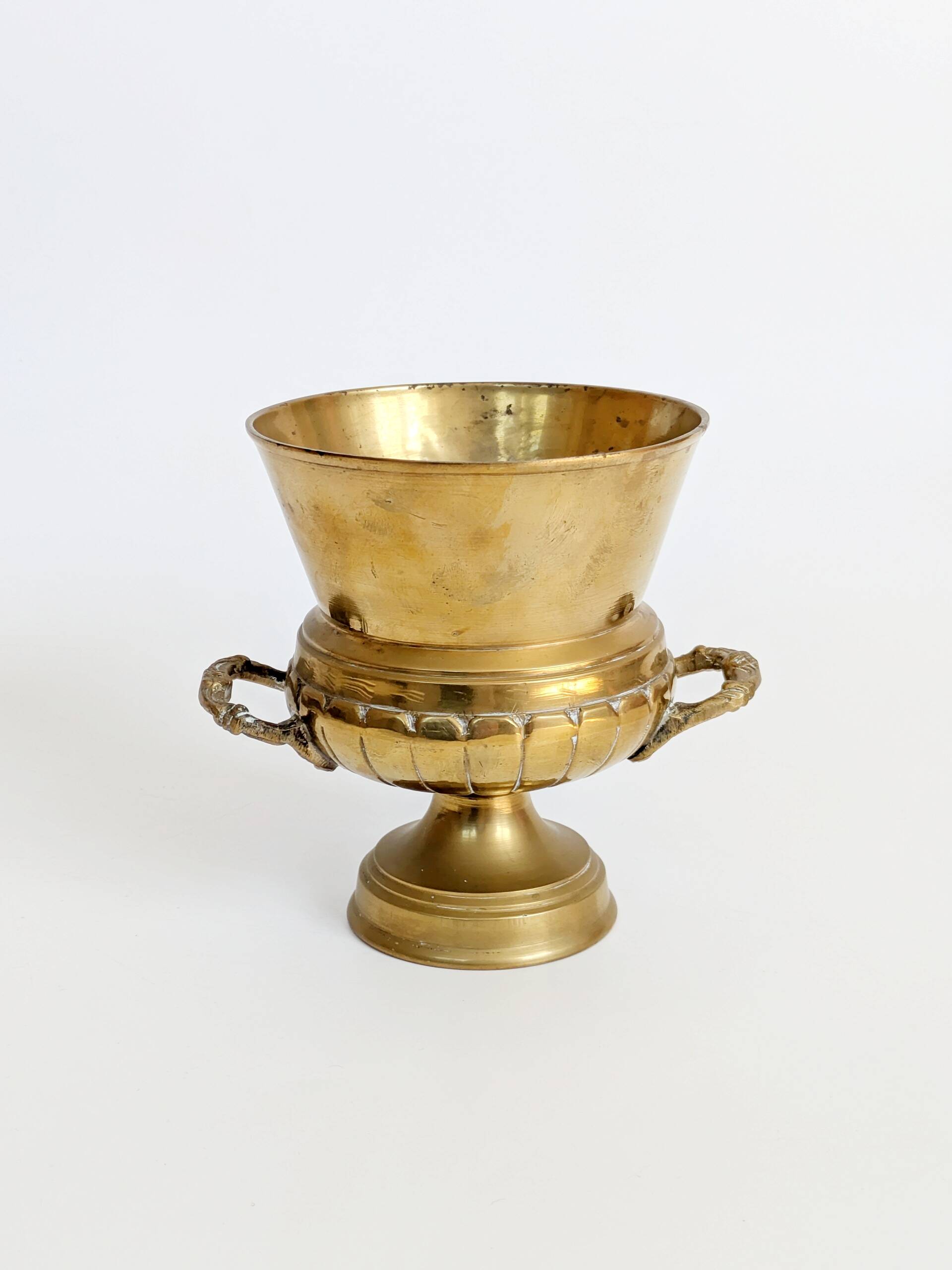Vintage brass cache-pot on a stand with handles, classic decor.