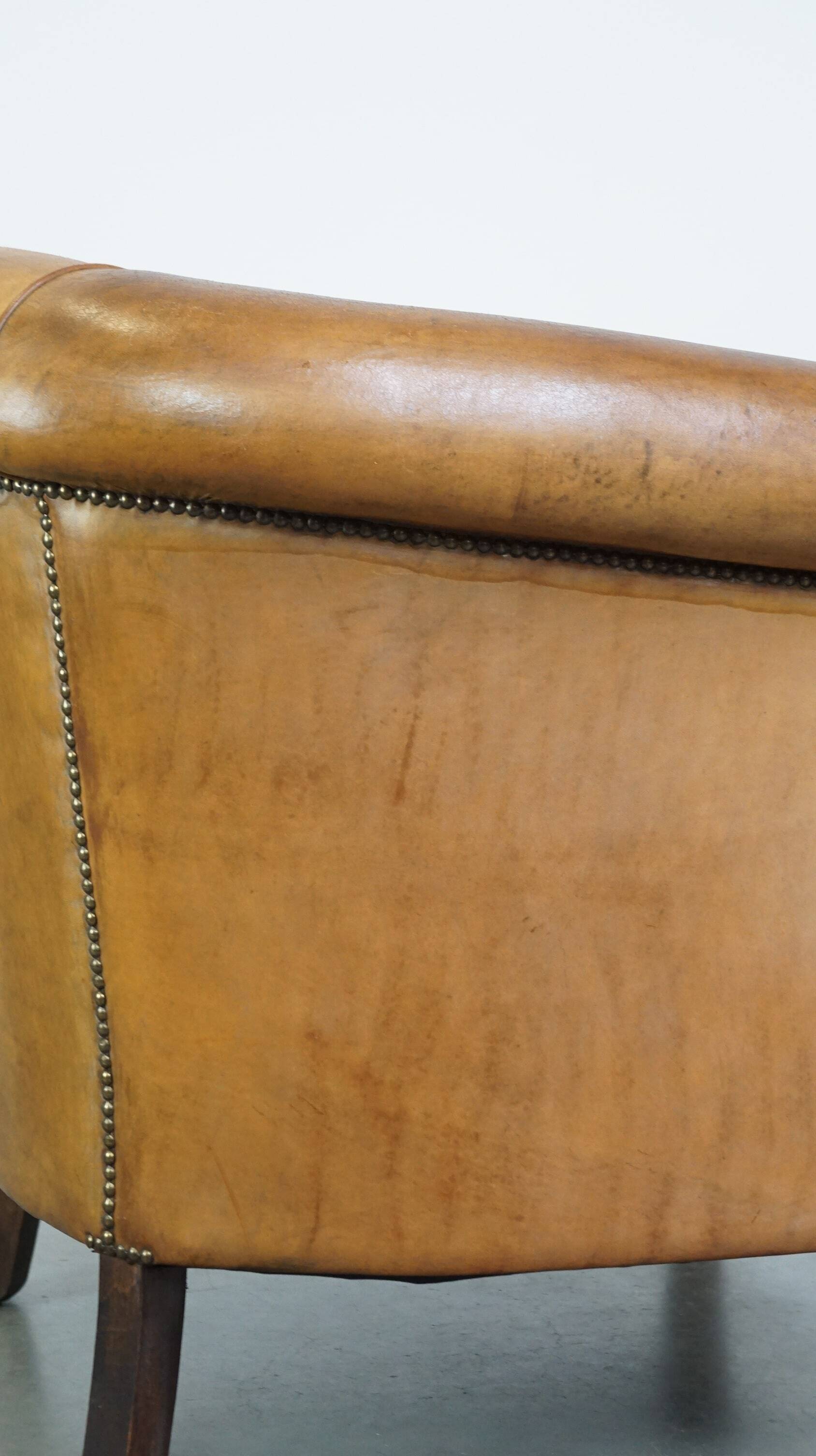 Comfortable, cozy, warm colored sheepskin club chair finished with decorative nails