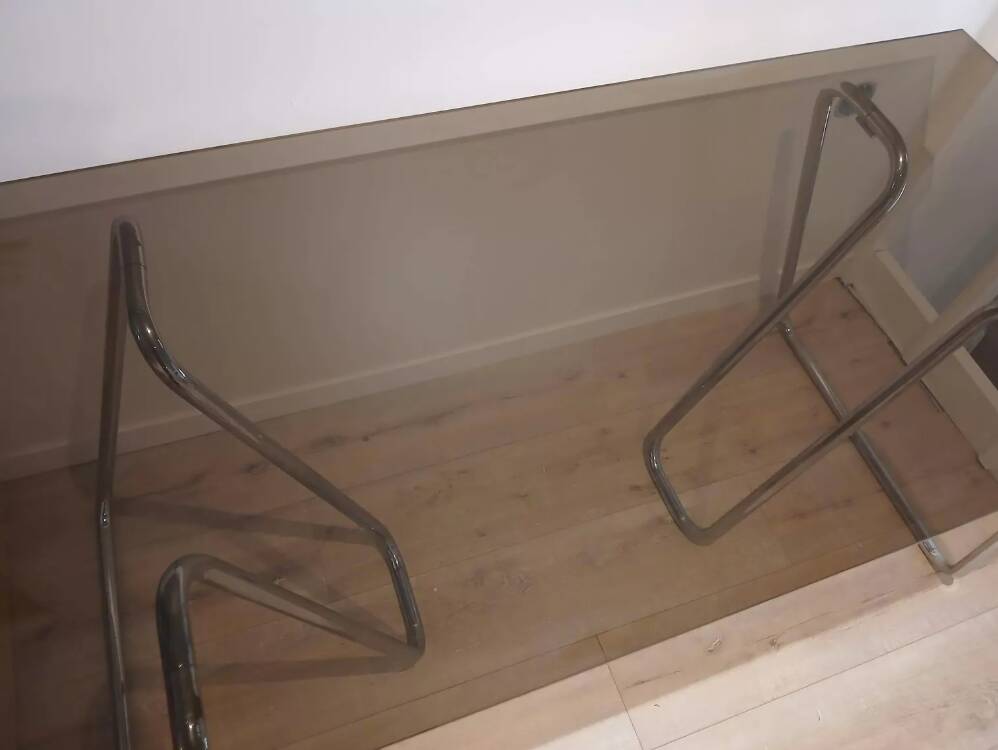 Smoked glass desk on tubular chrome trestles, 1970s design.