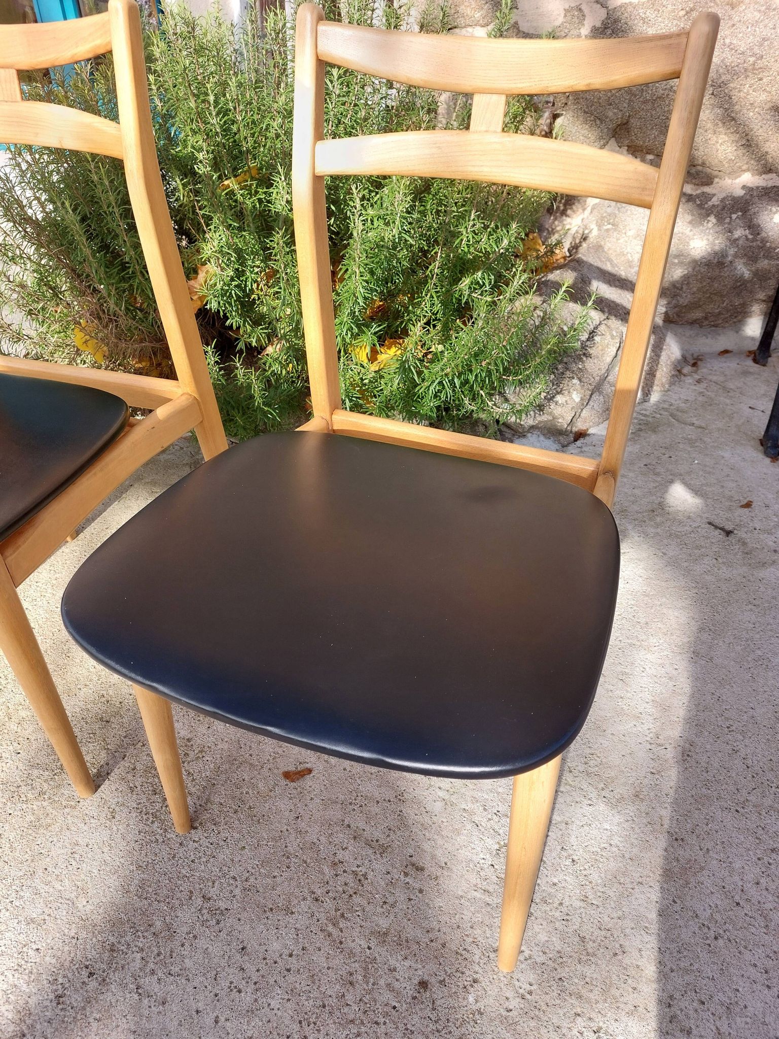 3 Scandinavian style chairs, light wood and black faux leather.
