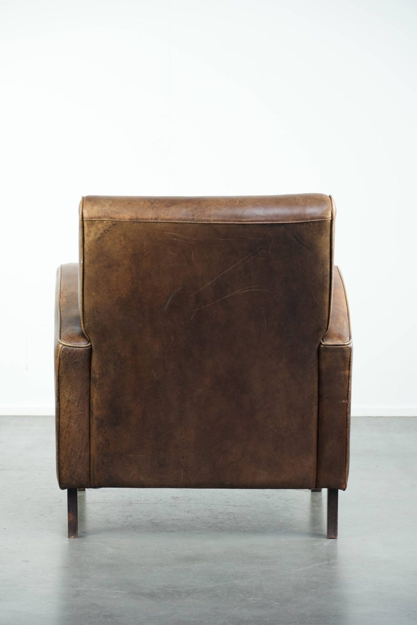 Set of a sheepskin armchair and ottoman finished with matching piping