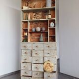 Craft cabinet with drawers with a very old tobacco advertisement in the background