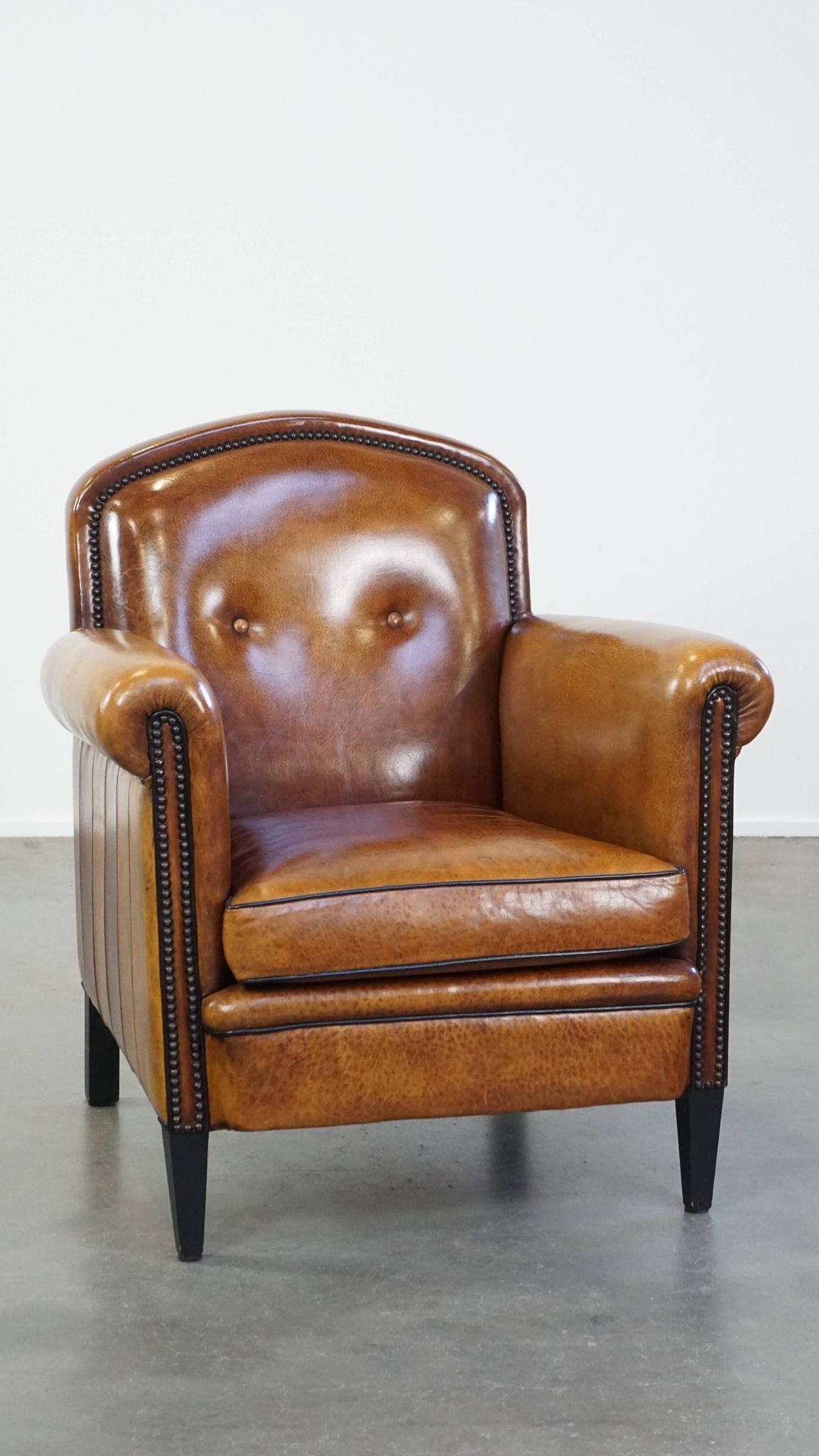 Sheep leather design armchair finished with decorative nails and black piping