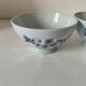 Two vintage farm bowls on a pale blue pedestal with floral decoration.