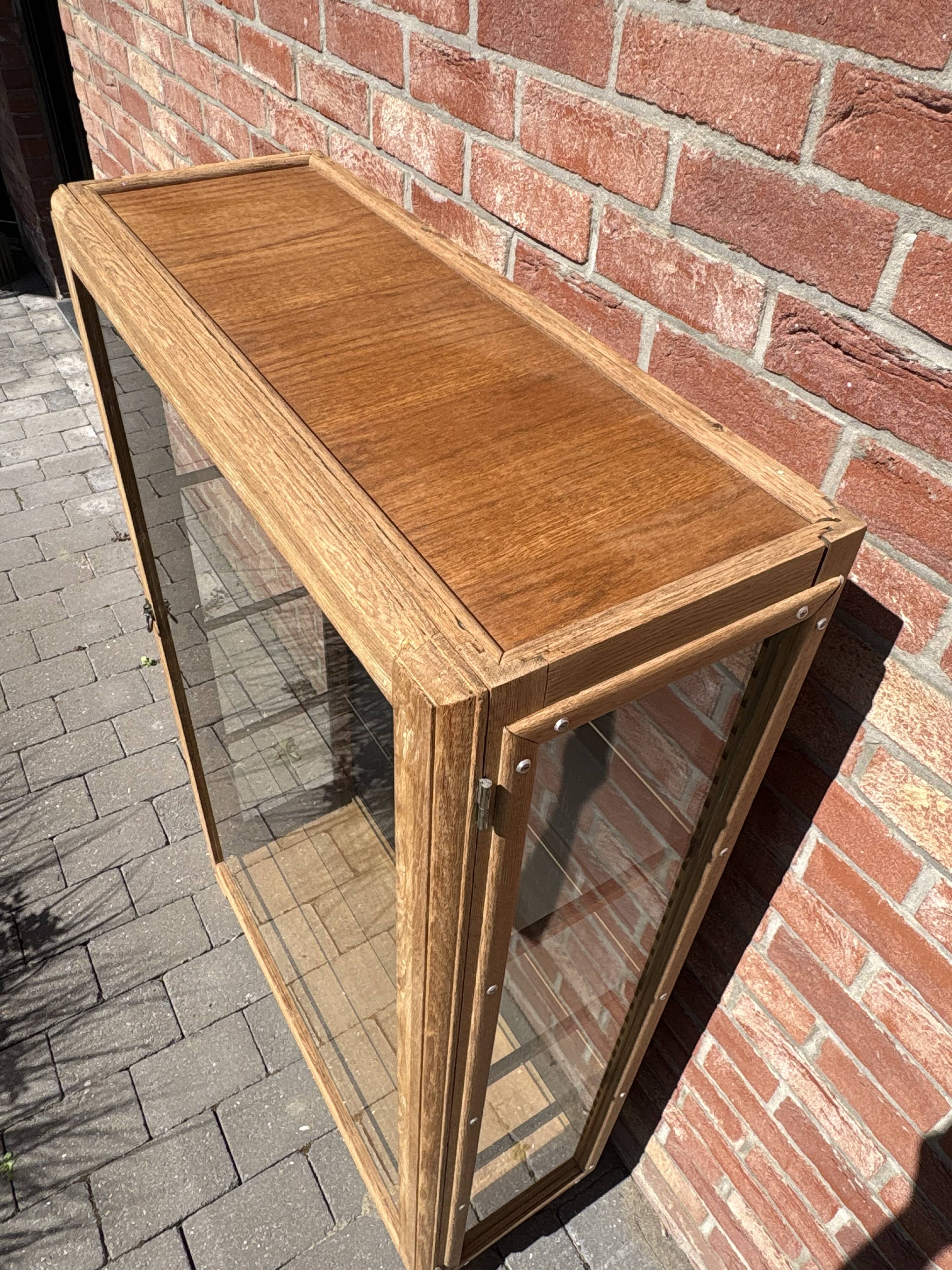 Restored antique oak display cabinet, black background, glass shelves.