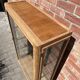 Restored antique oak display cabinet, black background, glass shelves.