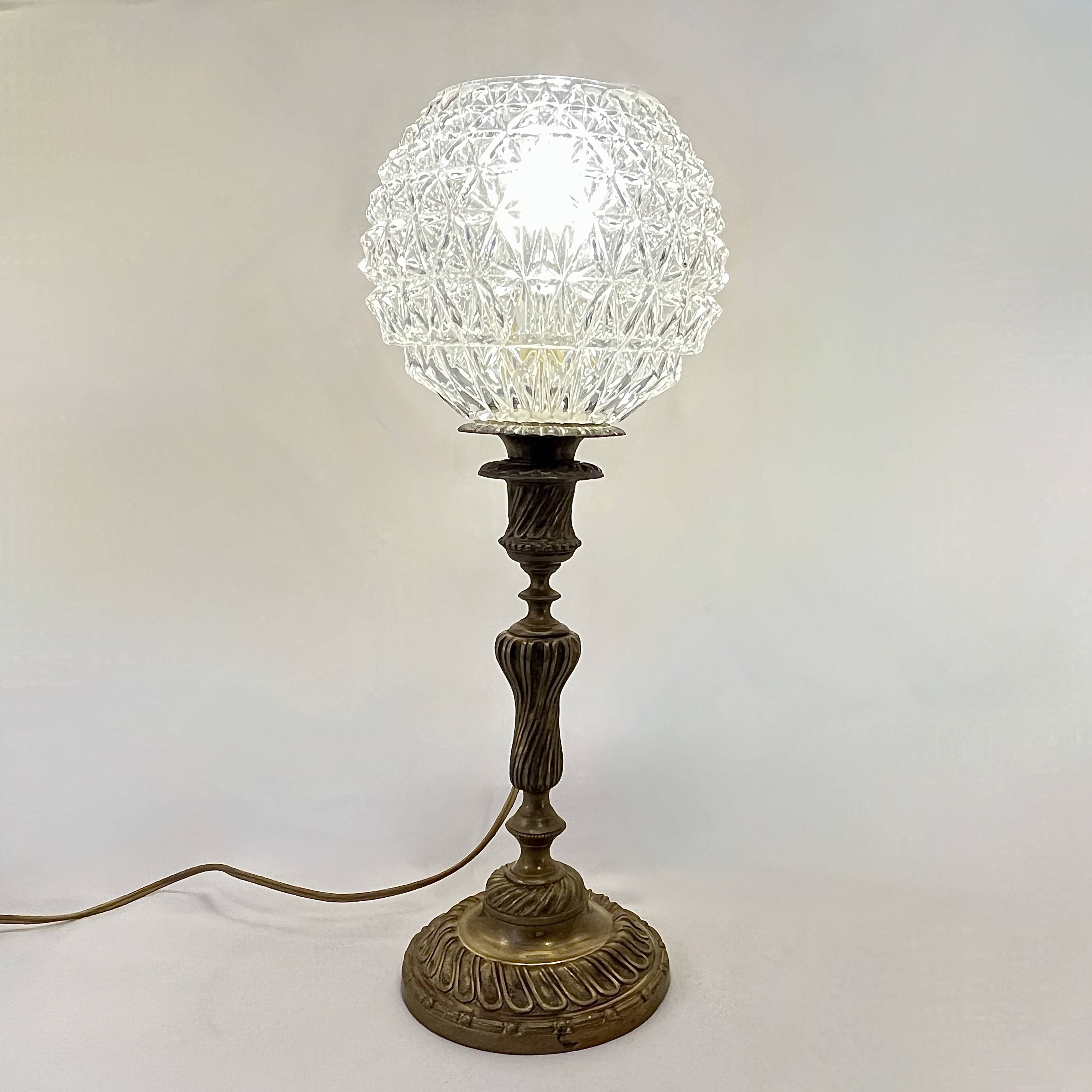 Antique brass foot lamp with glass globe and diamond point.