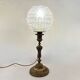 Antique brass foot lamp with glass globe and diamond point.
