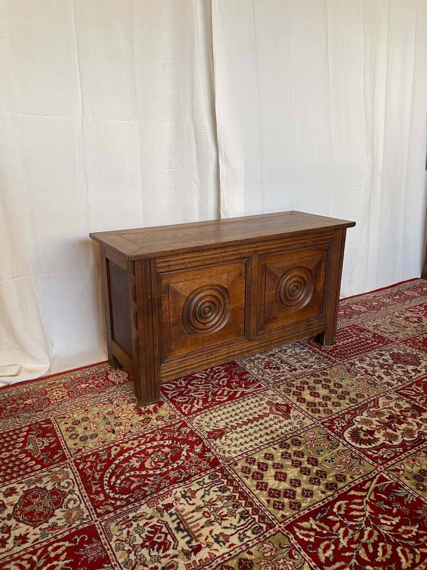Small antique oak chest with carved panels.