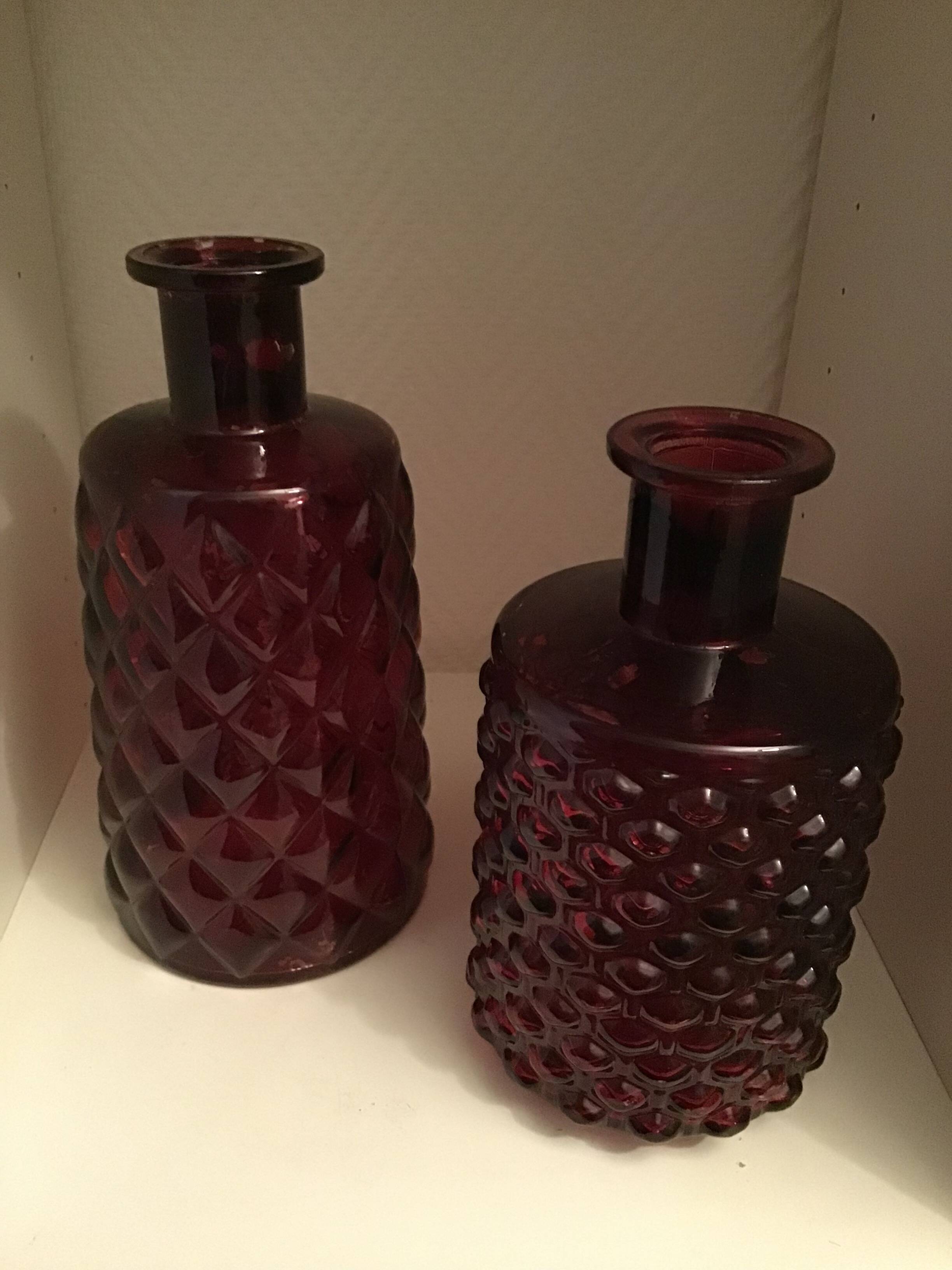 2 red molded glass bottles or jars