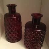 2 red molded glass bottles or jars