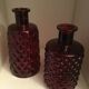 2 red molded glass bottles or jars