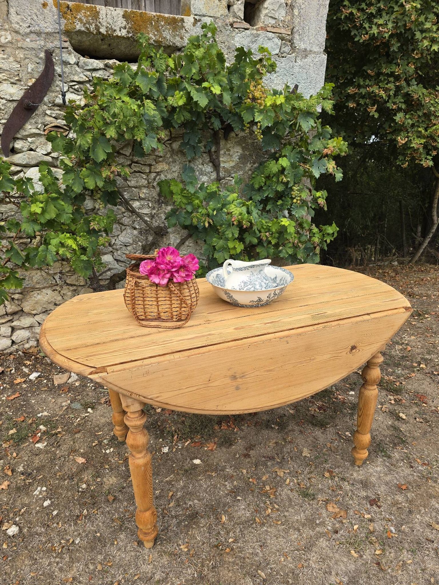 Folding drop-leaf table made of raw solid wood.