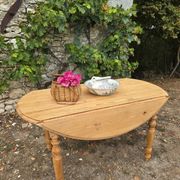 Folding drop-leaf table made of raw solid wood.