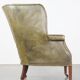Green antique barrel back wingback chair on wheels