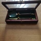 Magnifying glass and paper cutter in a vintage wooden box