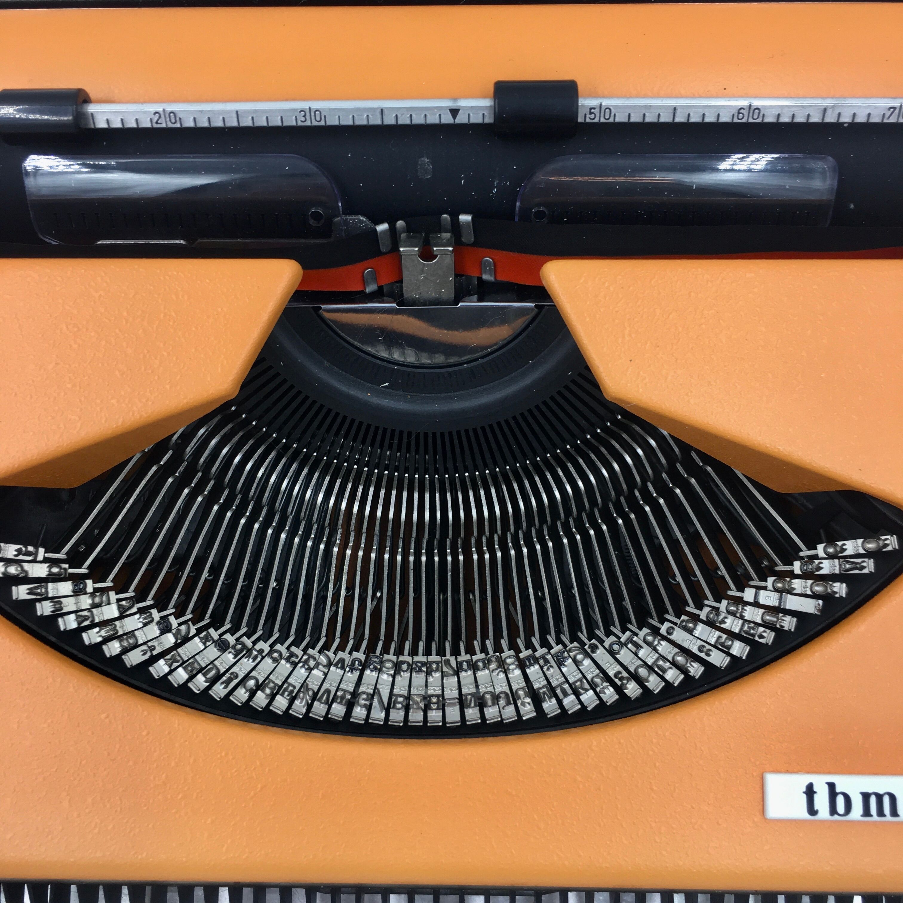 WE typewriter orange