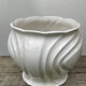 White ceramic pot cache of flower slip and old green foliage