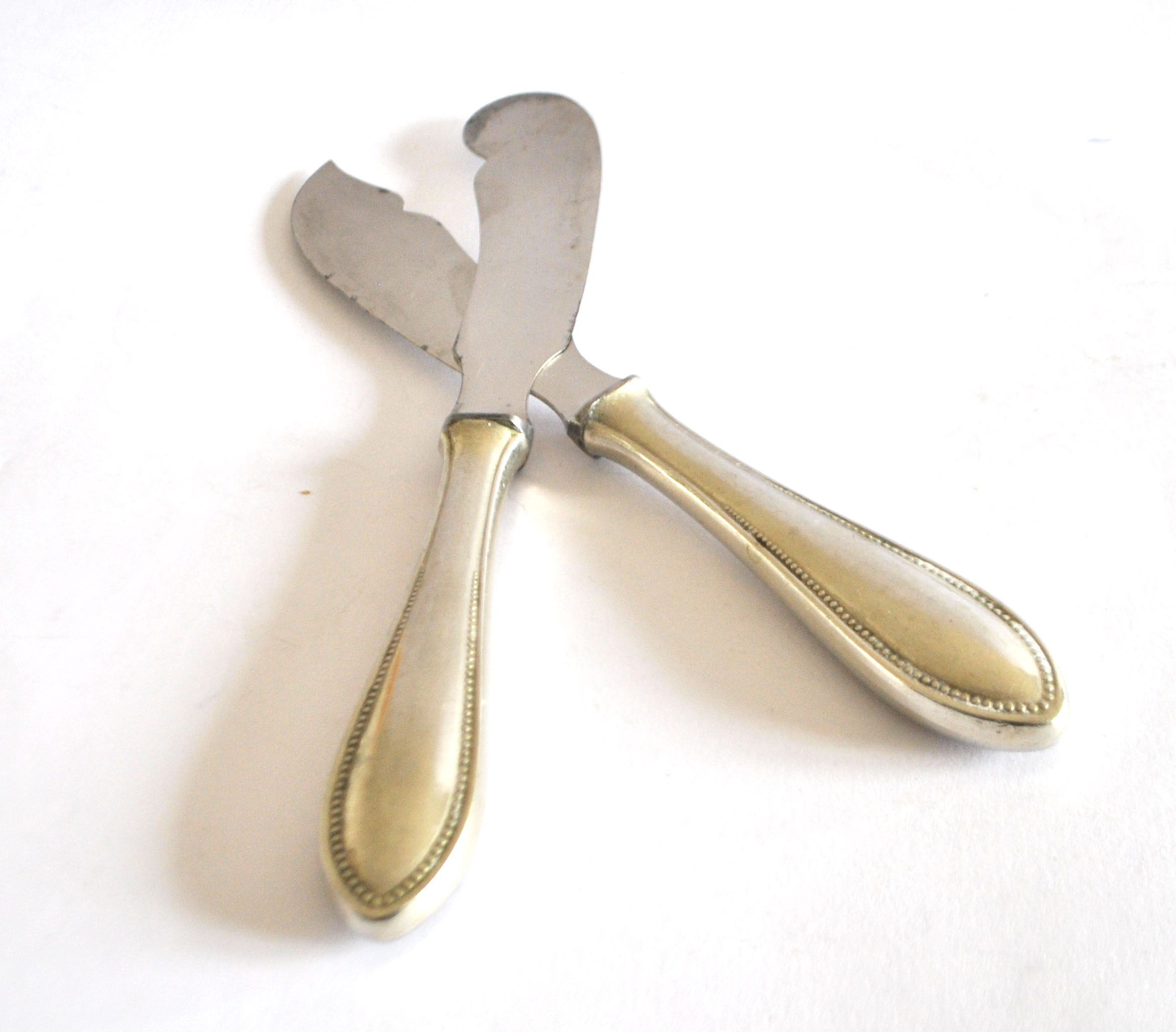 Two antique service knives in silver-plated metal, pearl frieze gowe alpacca.