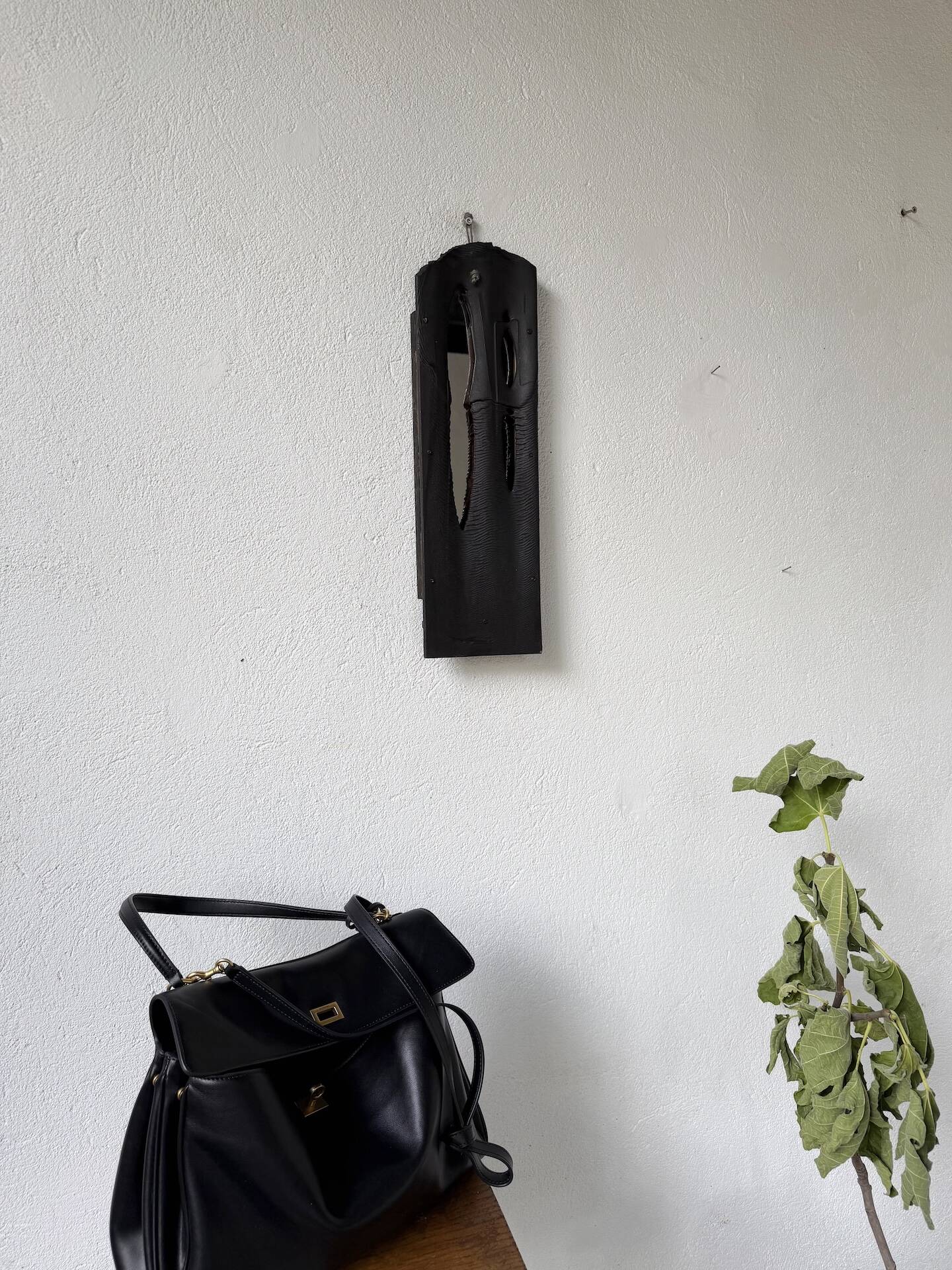 Brutalist hammered mirror, free-form, patinated metal.
