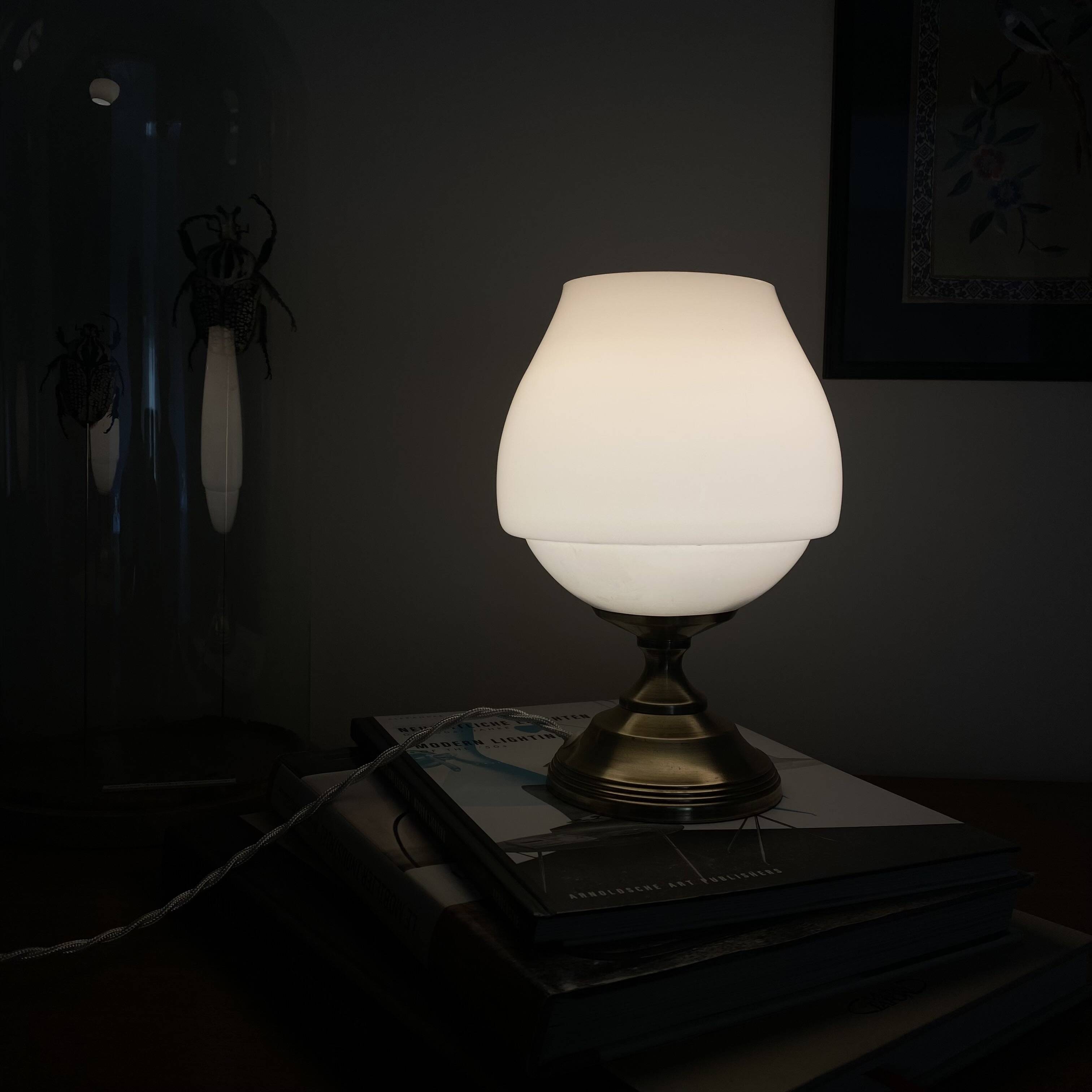 Antique white opaline glass globe table lamp with a brass base.