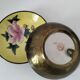 A pair of vintage Chinese decorative plates with floral designs on a yellow background.