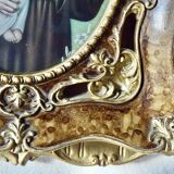 Old religious light frame in gilded stucco and curved glass