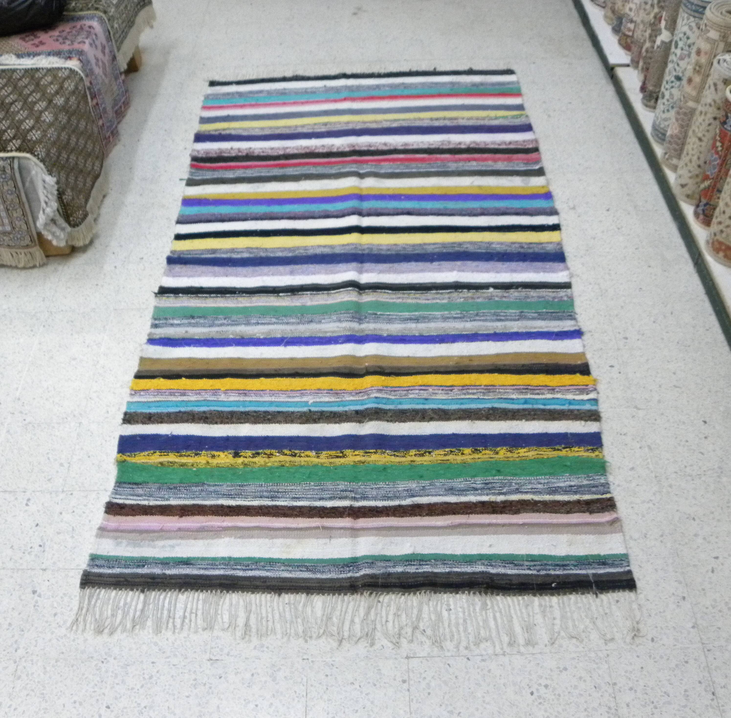 Vintage traditional nomadic kilim ethnic rug with multicoloured stripes.