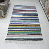 Vintage traditional nomadic kilim ethnic rug with multicoloured stripes.